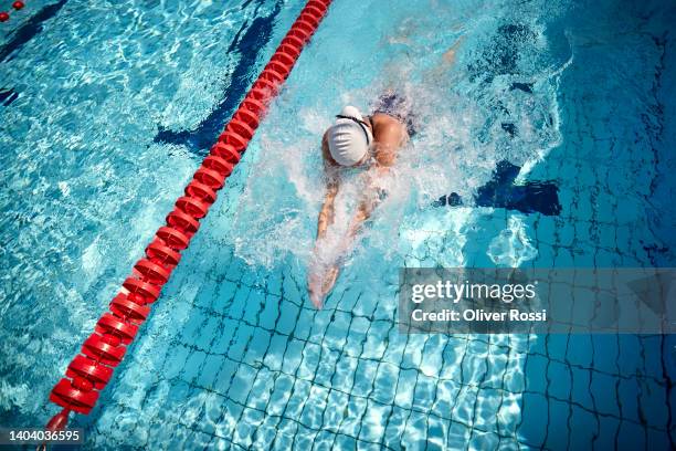 young woman swimming in an outdoor public swimming pool - swimming cap stock pictures, royalty-free photos & images