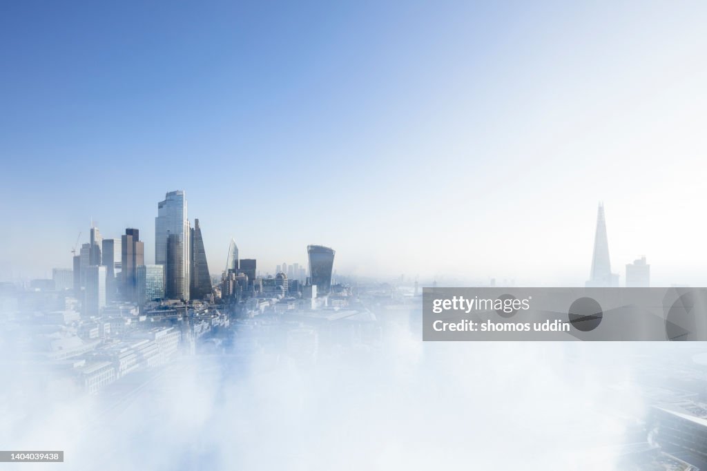 London city skyline emerging through clouds - arial view