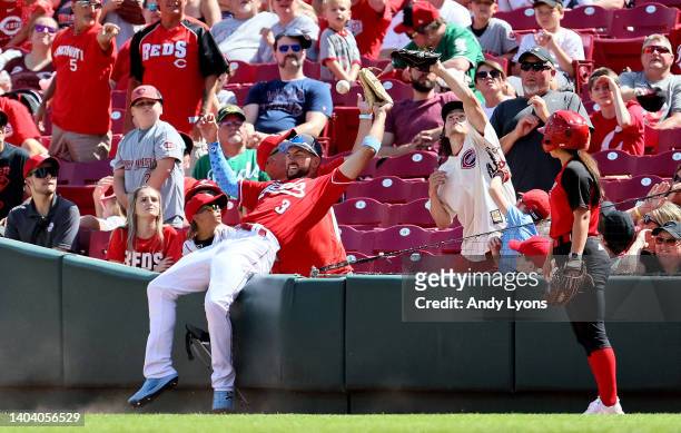 Albert Almora Jr of the Cincinnati Reds battles for a foul ball with fans in the ninth inning against the Milwaukee Brewers at Great American Ball...