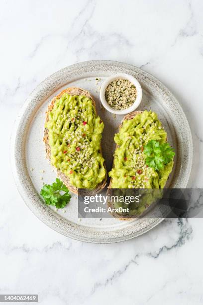 toast with mashed avocado and hemp seeds - toastbrot stock-fotos und bilder