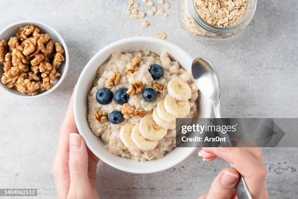 oatmeal porridge bowl with banana, blueberry and walnuts - geheel stockfoto's en -beelden