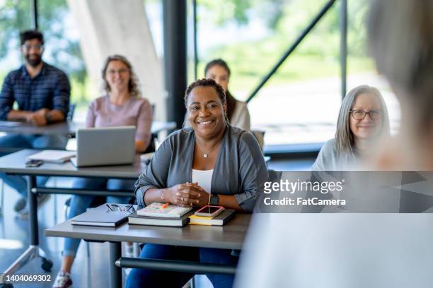 mature students listening in class - female development stockfoto's en -beelden