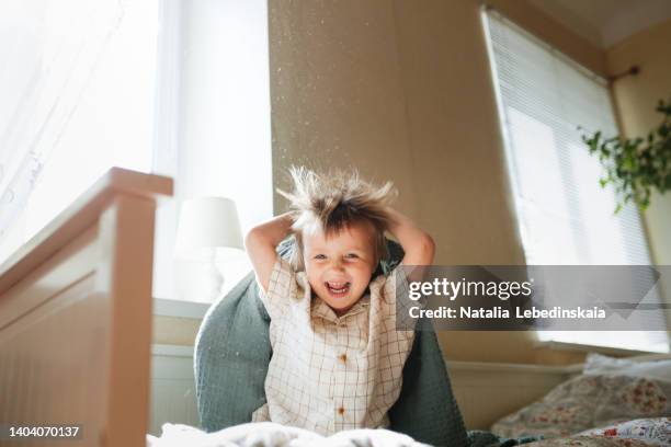 european toddler kid playing hide and seek under blanket - blonde cheering stock-fotos und bilder