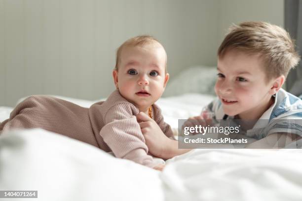 süßes kleines mädchen und ihr bruder zu hause - baby girls stock-fotos und bilder