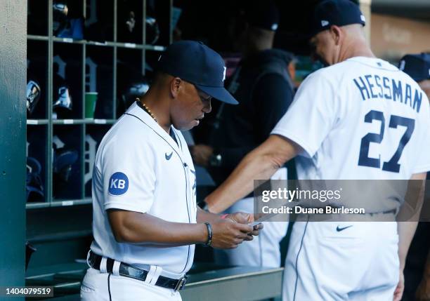 Third base coach Ramon Santiago of the Detroit Tigers checks a scouting report before a game against the Texas Rangers at Comerica Park on June 16 in...