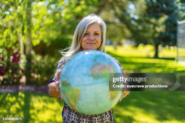 mulher adulta madura segurando um globo no colorado ocidental vivendo o futuro da terra série de fotos - one world - fotografias e filmes do acervo