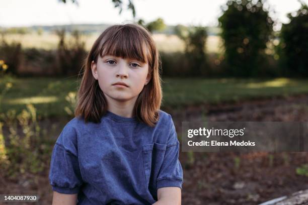 portrait of a serious girl schoolgirl outdoors in the park - girl portrait stock-fotos und bilder