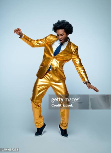 hombre disfrutando y bailando sobre fondo azul - glamour fotografías e imágenes de stock