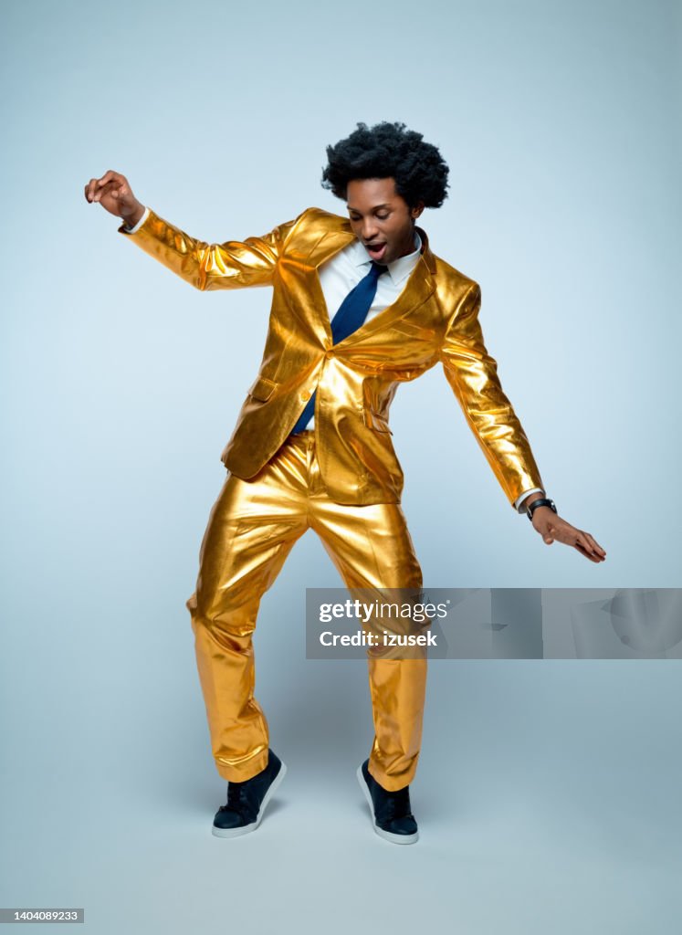 Man enjoying and dancing against blue background