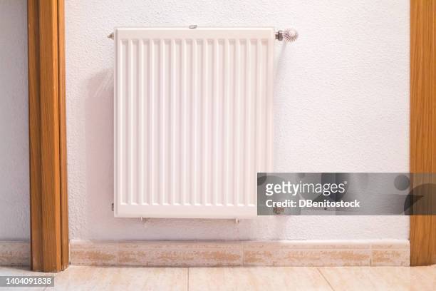 white iron central heating radiator inside a house. concept of gas, crisis, renewable energy and fossil energy. - smelting stock-fotos und bilder