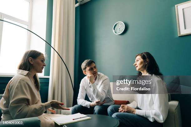 three people are talking in the office - people family group sad stock pictures, royalty-free photos & images