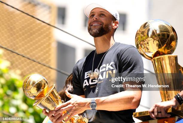 Stephen Curry of the Golden State Warriors celebrates with the NBA Championship Trophy and his NBA Finals Most Valuable Player Award during the...