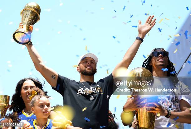 Stephen Curry and Damion Lee of the Golden State Warriors celebrate with the NBA Championship Trophy and Curry's NBA Finals Most Valuable Player...