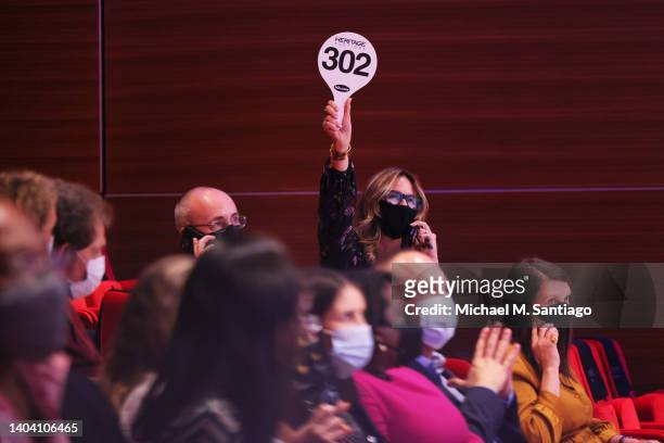 Bidder raises an auction paddle during a charity auction of the 2021 Nobel Peace Prize of Dmitry Muratov, editor-in-chief of the Russian newspaper...