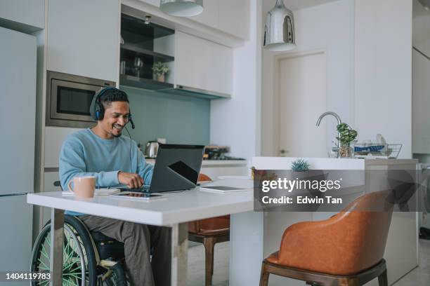 asia indian with disability  sitting on wheelchair in dinning room video call with laptop - camera operator stock pictures, royalty-free photos & images