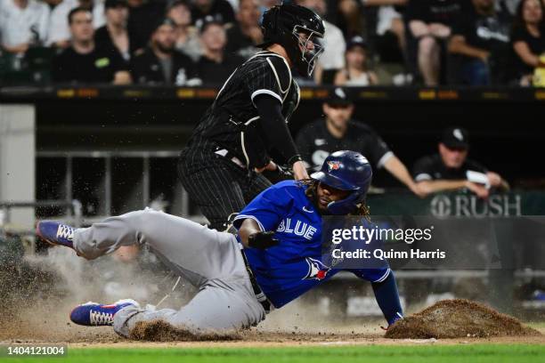 Vladimir Guerrero Jr. #27 of the Toronto Blue Jays slides into home base to score in the sixth inning against Reese McGuire of the Chicago White Sox...
