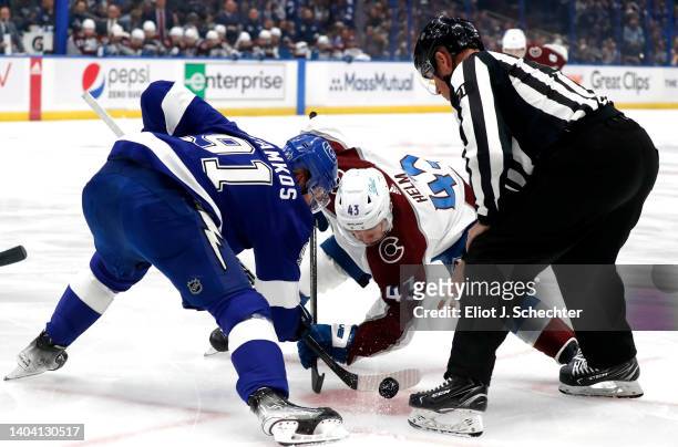 Steven Stamkos of the Tampa Bay Lightning faces off against Darren Helm of the Colorado Avalanche in the first period of Game Three of the 2022 NHL...