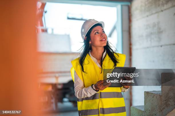 latin female engineer inspecting construction progress - civil engineer stock pictures, royalty-free photos & images