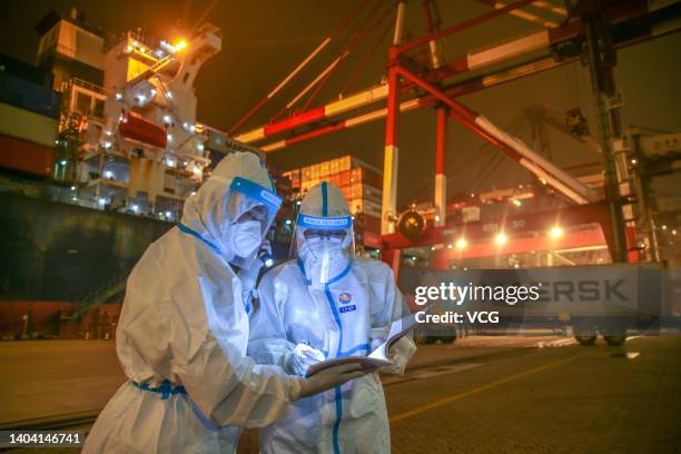 Immigration inspection officers wearing personal protective equipment patrol a terminal at the Qingdao Port on June 20, 2022 in Qingdao, Shandong...