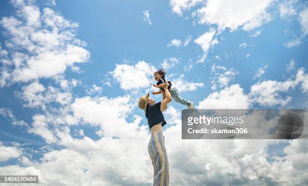 positive emotion asian mother lifting daughter up in the sky  outdoor,domestic life - cute asian woman stock pictures, royalty-free photos & images