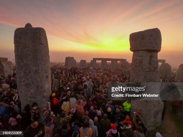 People gather for sunrise at Stonehenge, on June 21, 2022 in Wiltshire, England. The summer solstice occurs on June 21st, it is the longest day and...