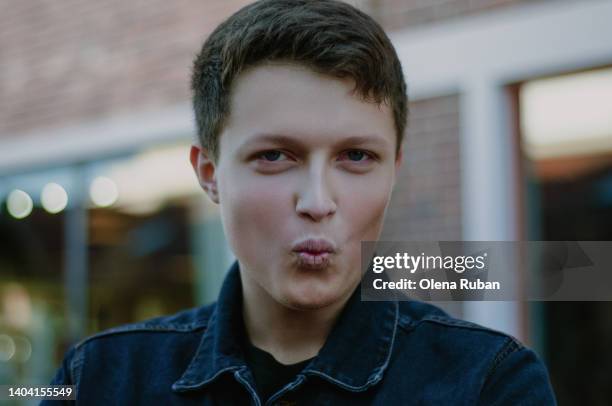 young man puckering lips outdoors. - teasing stock pictures, royalty-free photos & images