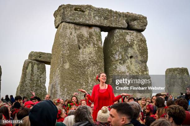 Woman sings during sunrise at Stonehenge, on June 21, 2022 in Wiltshire, England. The summer solstice occurs on June 21st, it is the longest day and...