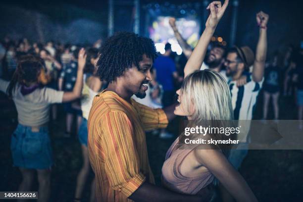 couples insouciants s'amusant tout en dansant sur le festival de musique la nuit. - couple concert photos et images de collection