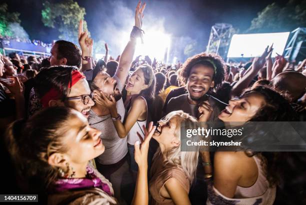 fröhliche freunde tanzen und unterschreiben auf musikfestival bei nacht. - concert audience stock-fotos und bilder