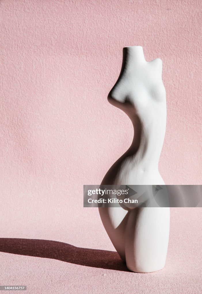 The female body pottery against pink background