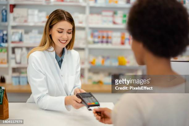accepting payment for a healthcare purchase - paying doctor stock pictures, royalty-free photos & images