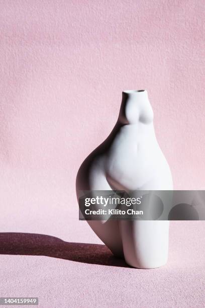 the female body pottery against pink background - body positive stockfoto's en -beelden