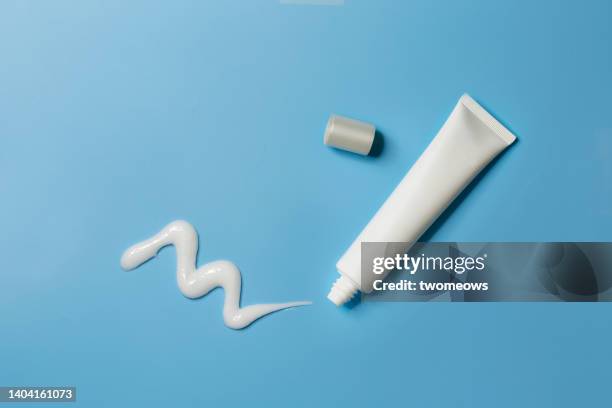 flat lay facial product in tube on blue background still life. - toothpaste stock-fotos und bilder