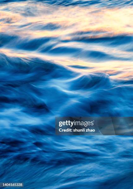ocean waves, reflections of sunlight at sunset - orange silk background stock-fotos und bilder