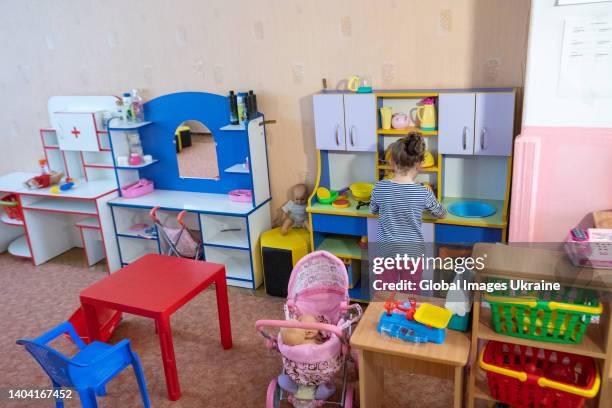 Girl plays at a toy kitchen in a playroom of a preschool on June 1, 2022 in Kyiv, Ukraine. Almost 400 children out of 100 who were registered in...