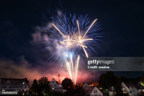 big fireworks over the city of herisau in switzerland on the national holiday august 1. - raket bildbanksfoton och bilder