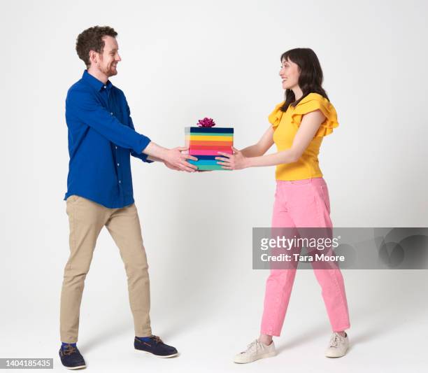 two people giving present - 2 adult women studio shoot not hug not children stock pictures, royalty-free photos & images