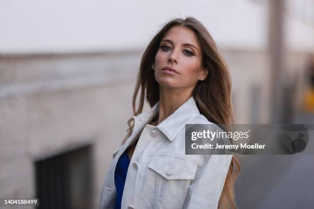 Cathy Hummels seen wearing a blue jumpsuit from Hugo Boss and a white logo cropped denim jacket from Fendi on June 15, 2022 in Berlin, Germany.