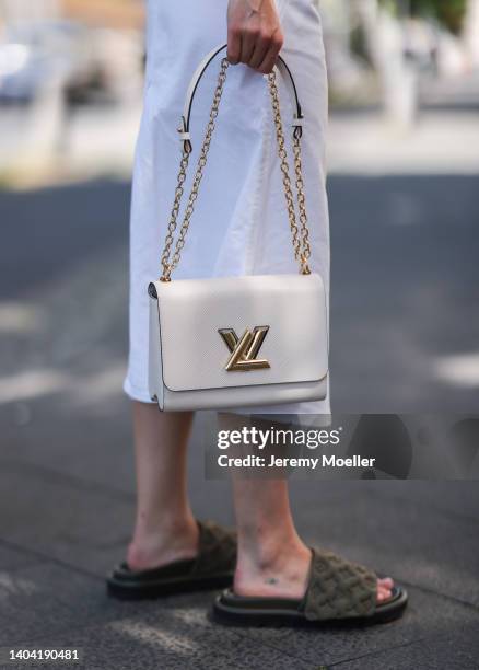 Lea Naumann seen wearing a white midi denim skirt from Louis Vuitton, a white leather Louis Vuitton Twist bag and khaki velour leather sandals from...