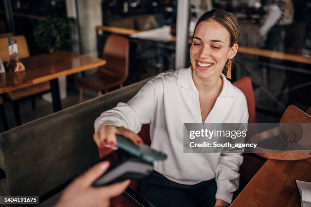 frau, die per smartphone bezahlt - rechnung restaurant stock-fotos und bilder