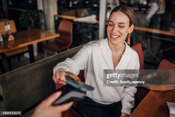 woman paying via smart phone - contactless payment stock pictures, royalty-free photos & images