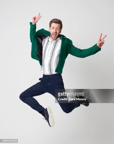 man jumping with peace sign - ピースサイン ストックフォトと画像
