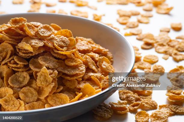 dry honey cornflakes in a ceramic plate on the dining table at home or on a white background. top view, copy space. the concept of healthy eating, vegetarian and vegan food for breakfast. - corn flakes ストックフォトと画像