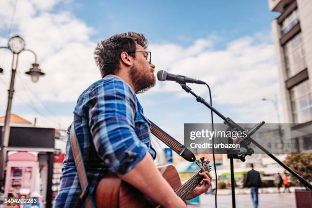 guitar player on a city square - acoustic guitarist stock pictures, royalty-free photos & images