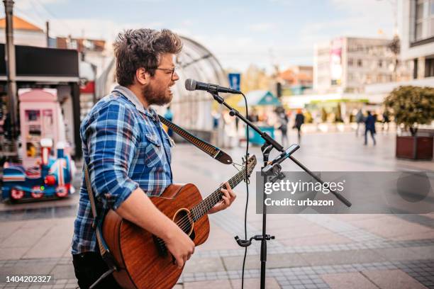 guitar player on a city square - busker stock pictures, royalty-free photos & images