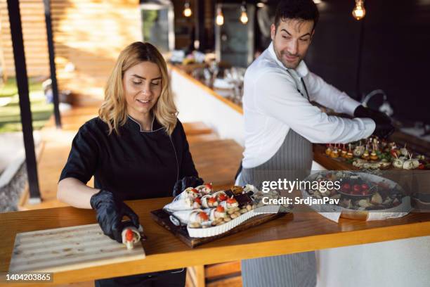 chefs preparando y organizando canapés para un banquete - abastecedor fotografías e imágenes de stock