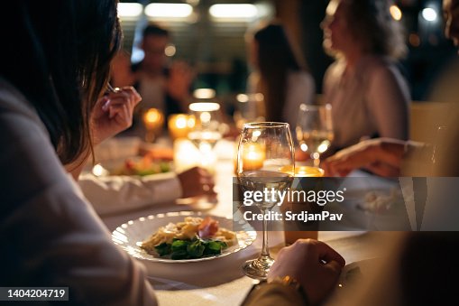 Unrecognizable multiracial female and male friends, having the dinner at the restaurant balcony Unrecognizable multiracial female and male friends, having the dinner at the restaurant balcony