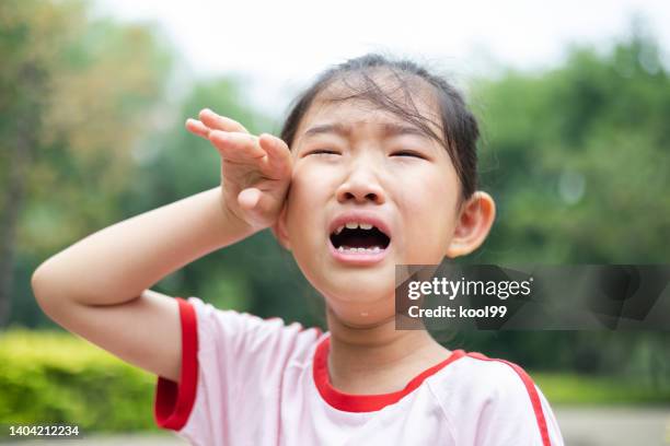 little girl crying and wipe tears with hand - mood moss stock pictures, royalty-free photos & images