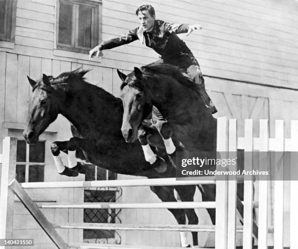 John Hendricks and his 'Flying Twins' steeds that he rides bareback in tandem, Pueblo, Colorado, 1947. Here they clear a four foot hurdle in perfect...