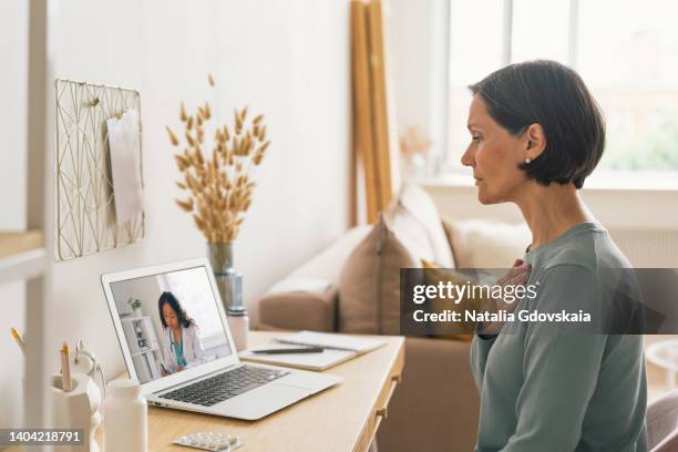 woman calling doctor online about chest pain or cough or heartburn. telemedicine concept. future teleconsulting. diagnostic from home. videoconference with therapist. sick female asking for help - old cough stock pictures, royalty-free photos & images